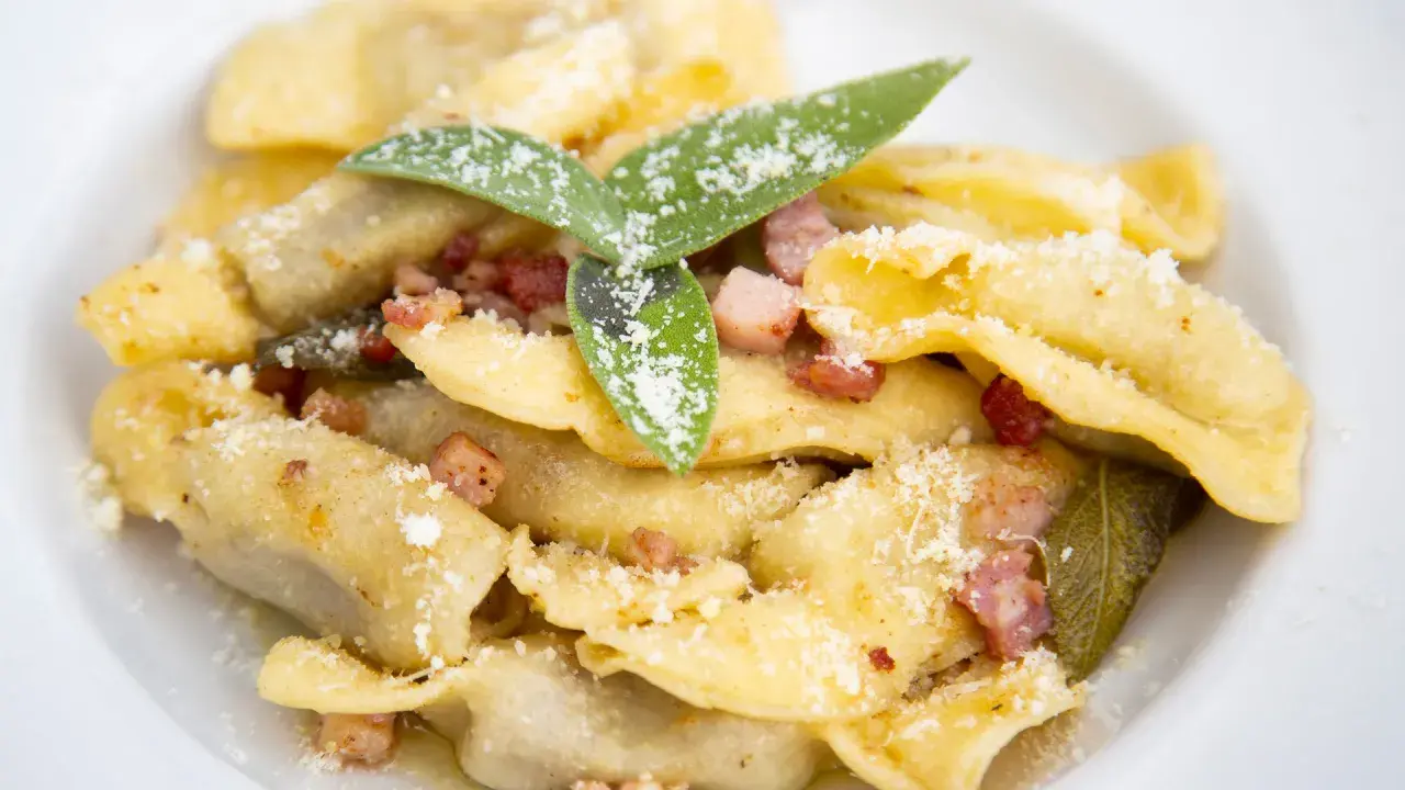 Ravioli fatti in casa con pancetta croccante, salvia e parmigiano, un assaggio dei piatti tipici bergamaschi.