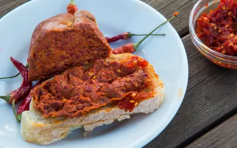 Fetta di pane con 'nduja e peperoncino, un assaggio di vero mangiare calabrese.