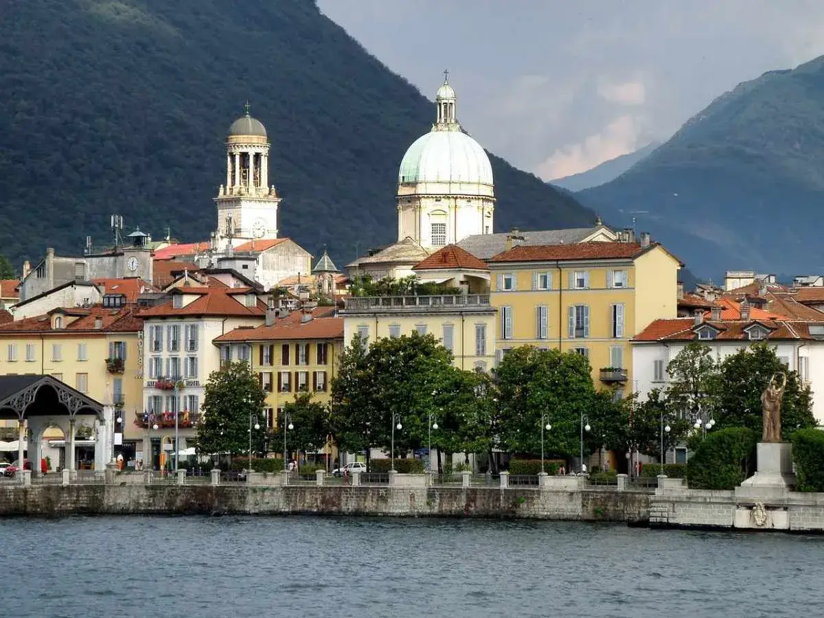 Vista sul lungolago di Stresa, con edifici colorati e cupole, ideale per scoprire cosa vedere in un giorno sul Lago Maggiore.