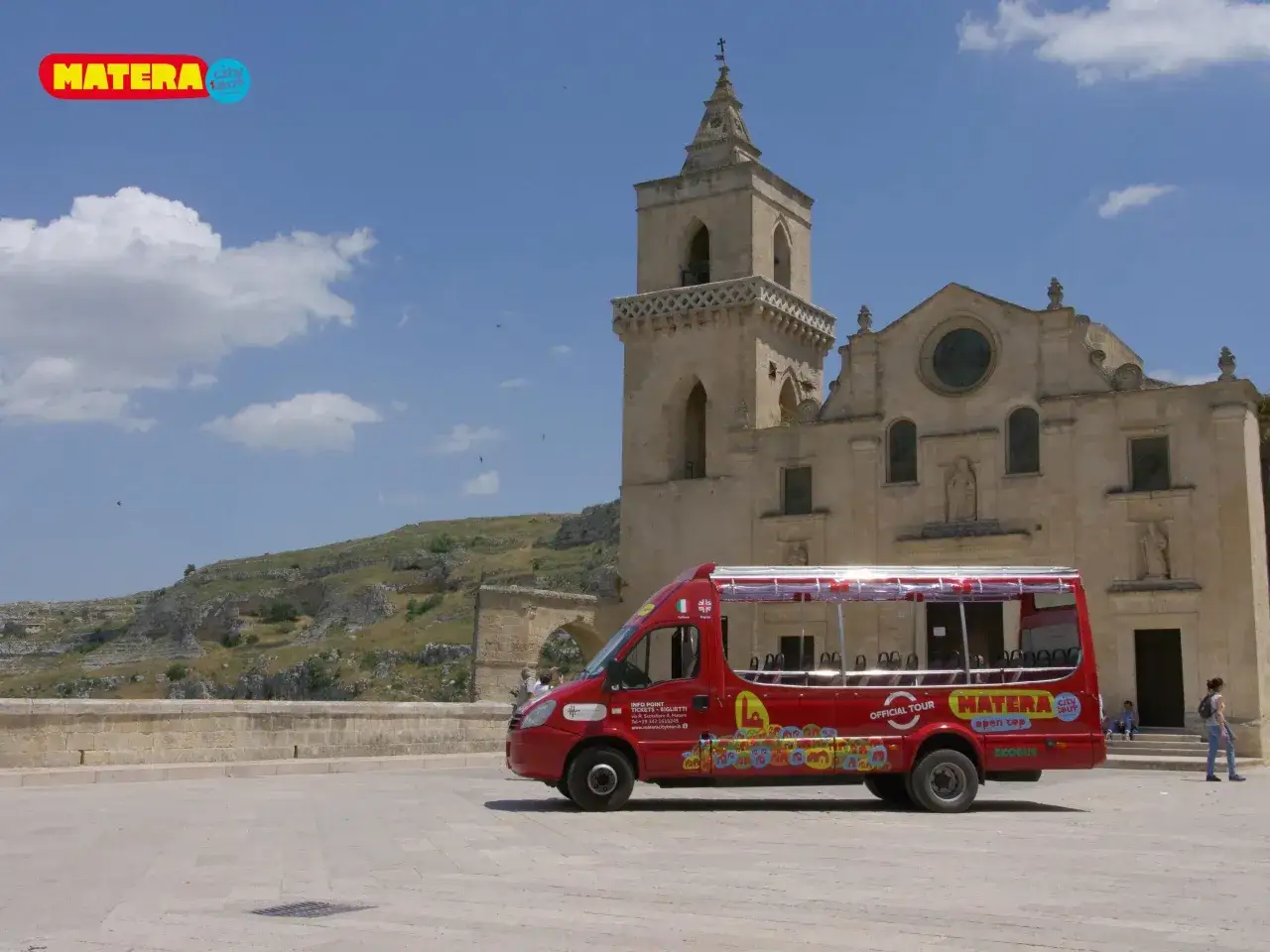 Un bus turistico rosso a Matera, con la scritta