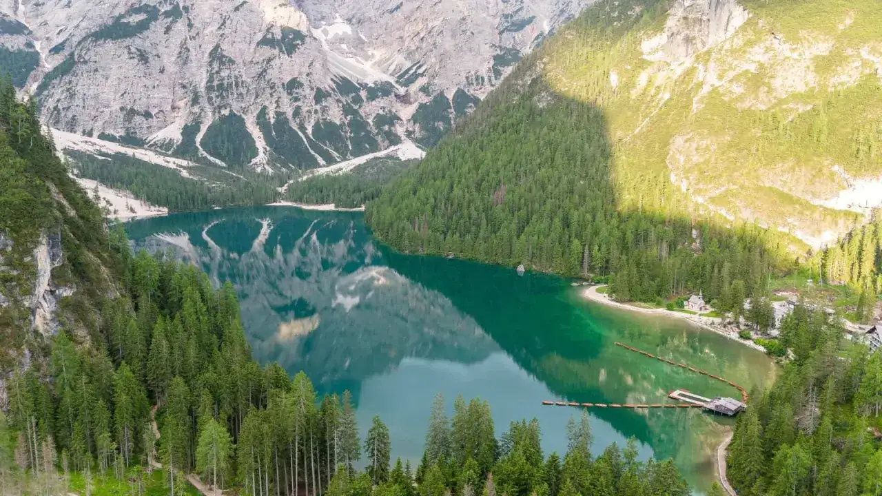 Lago di Braies, uno dei pi&ugrave; bei laghi in Italia da visitare, con montagne maestose e boschi di conifere che si specchiano nelle sue acque cristalline.