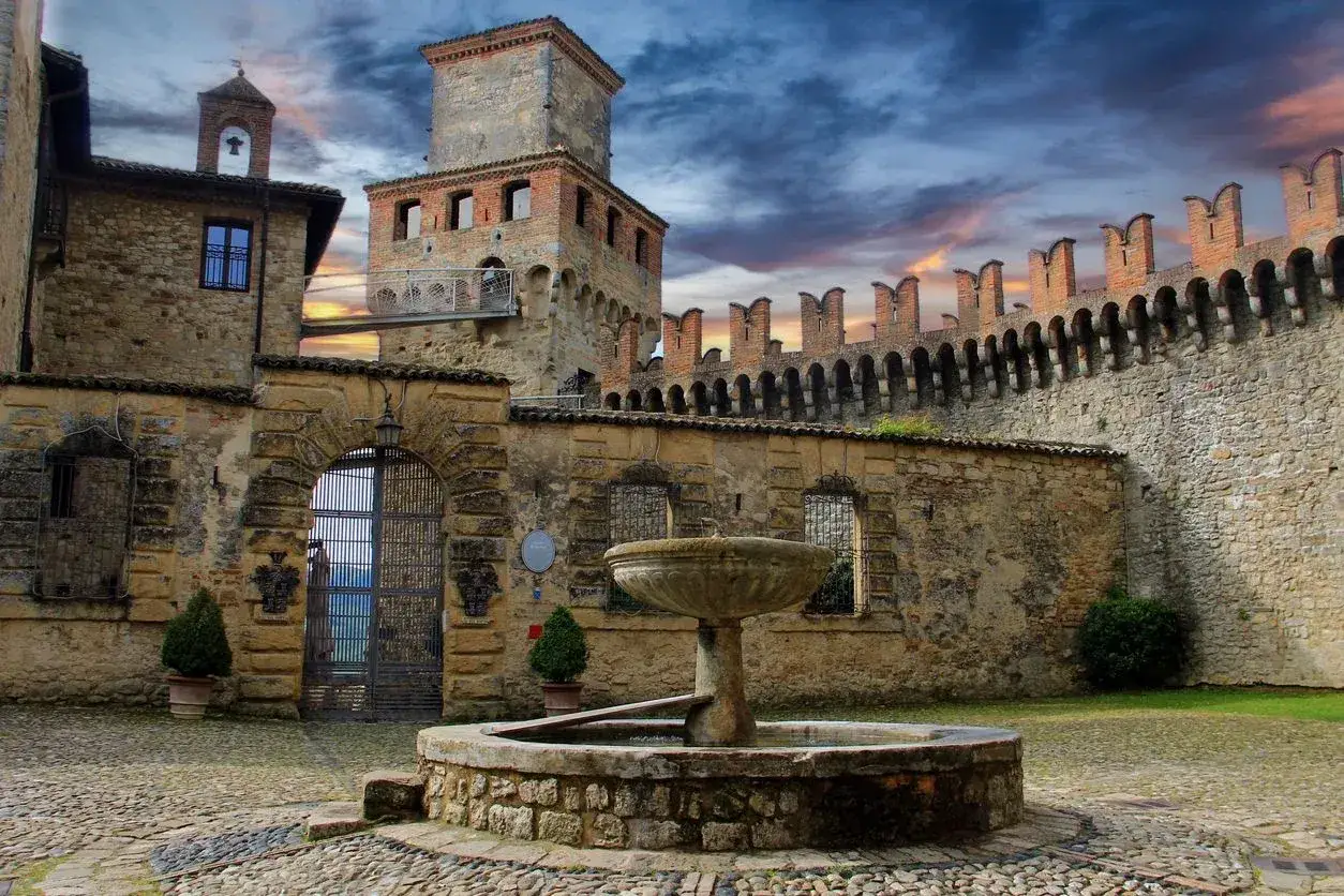 Cortile di un castello con fontana, ideale per scoprire cosa vedere a Parma e dintorni in 3 giorni.