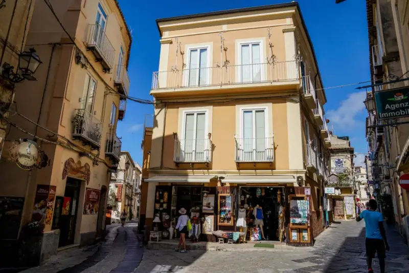 Un vicolo di Tropea con negozietti e palazzi color ocra, un'atmosfera che ricorda la porta vaticana.